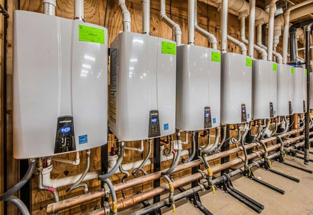 Row of tankless water heaters with copper manifold
